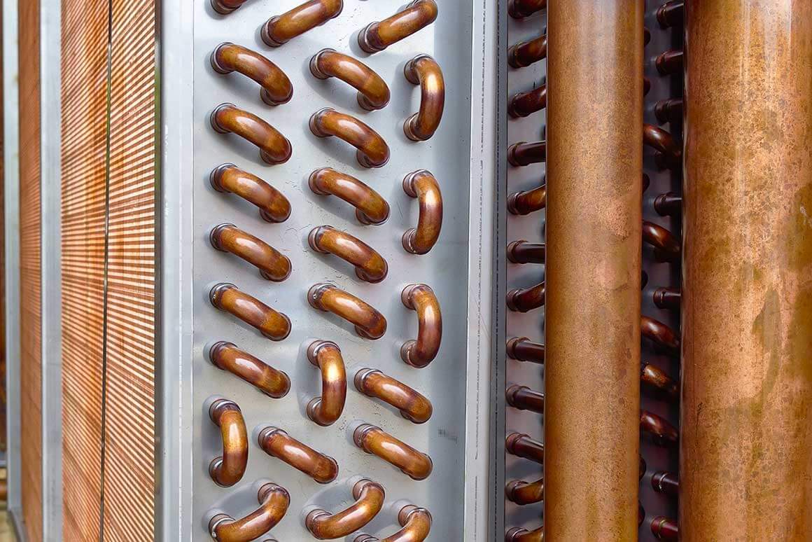 Close up shot of copper plain tubes of a condenser coil