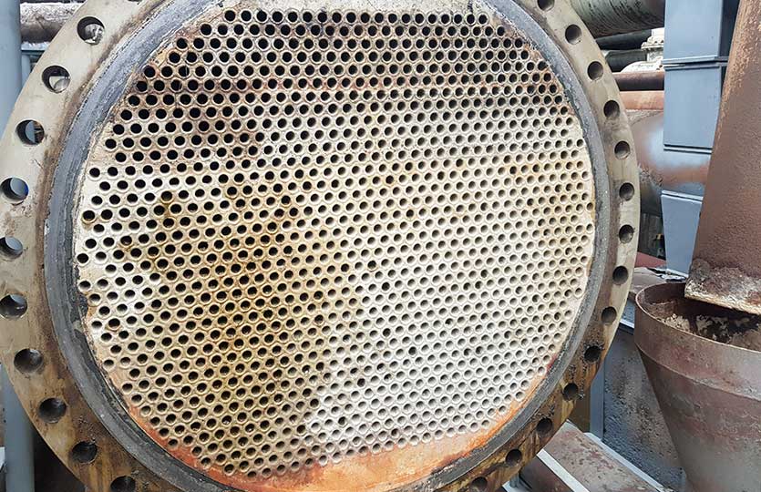 Shell-and-tube (shell-and-tube) heat exchanger for heat exchange between two streams close-up. Dirty pipes in the opened heat exchanger