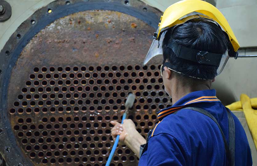 Mechanic is using brush to clean condenser tube of Chiller - HVAC System